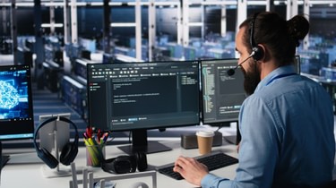 Engineer in data center wearing headset assisting users with AI