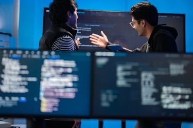 Software engineers collaborate on coding solutions i Stock