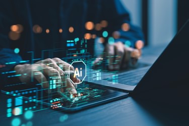 Human uses laptop computer to interact with AI stock image